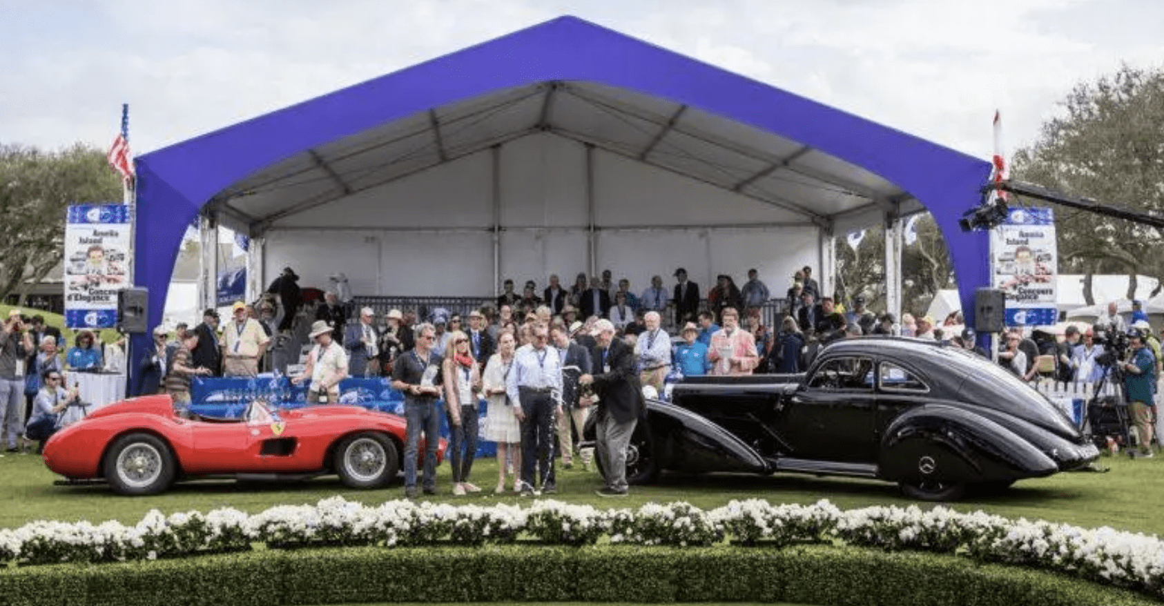 Car show with crowd and classic vehicles.