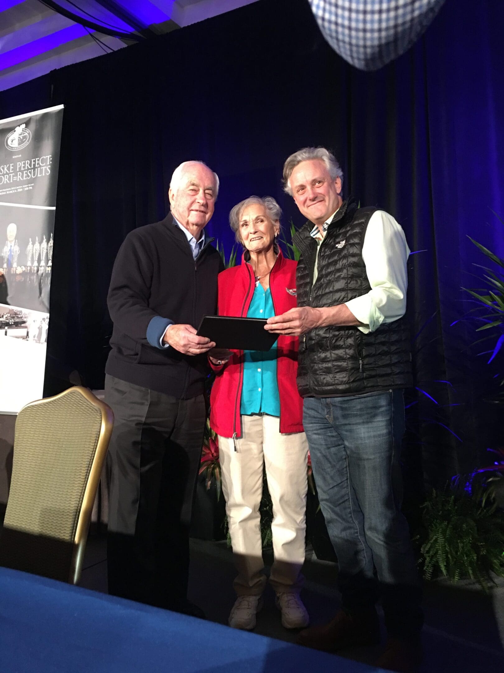 Three people posing on a stage together.