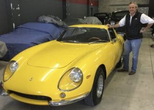 Man with vintage yellow sports car.