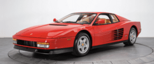 Red sports car on display platform.