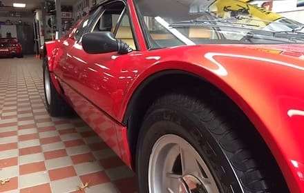 Shiny red vehicle parked indoors