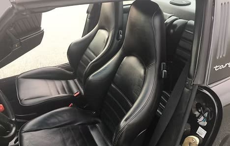 Two black leather seats in vehicle