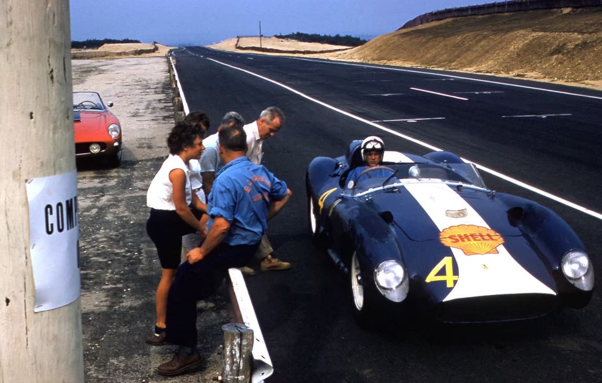 Group watching race car on asphalt road