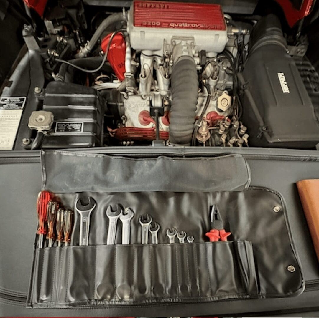Tool roll with wrenches in car engine bay