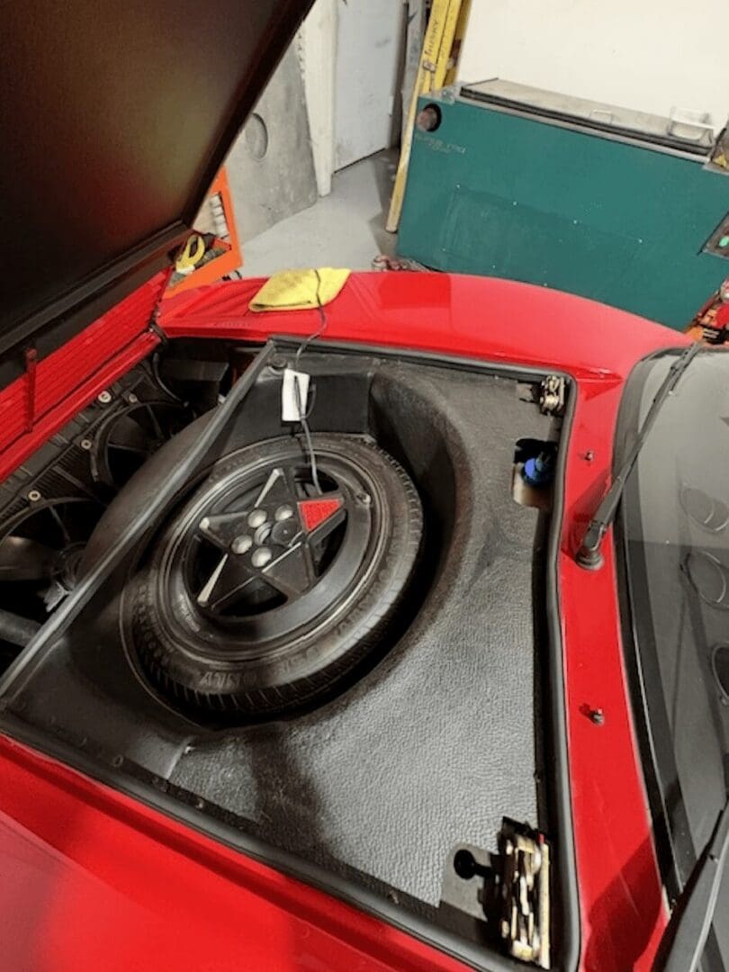 Red sports car front trunk with spare tire