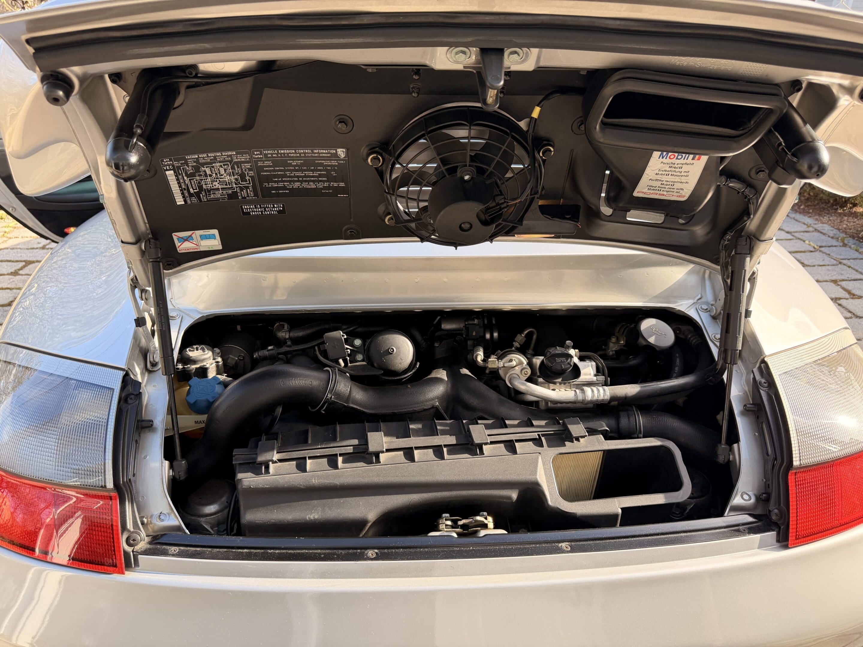 Open rear engine bay of silver sports car