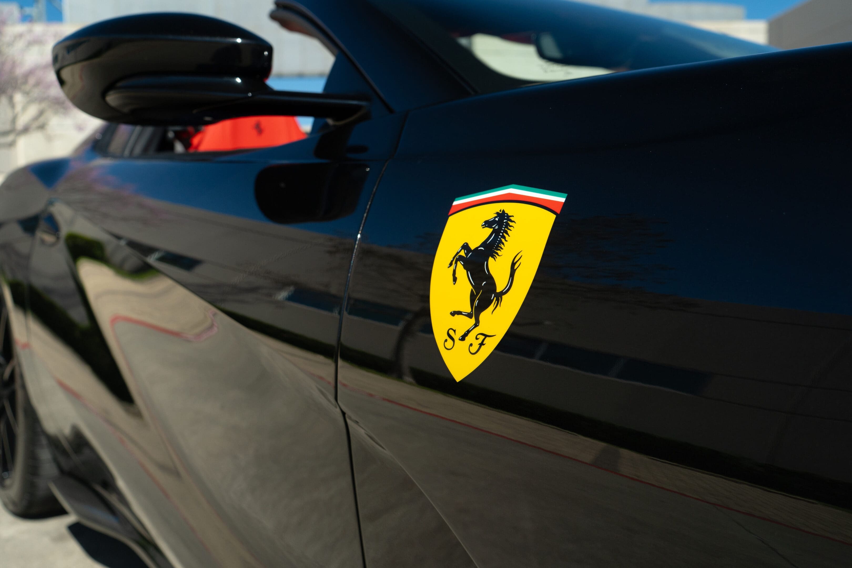 Ferrari emblem on black sports car