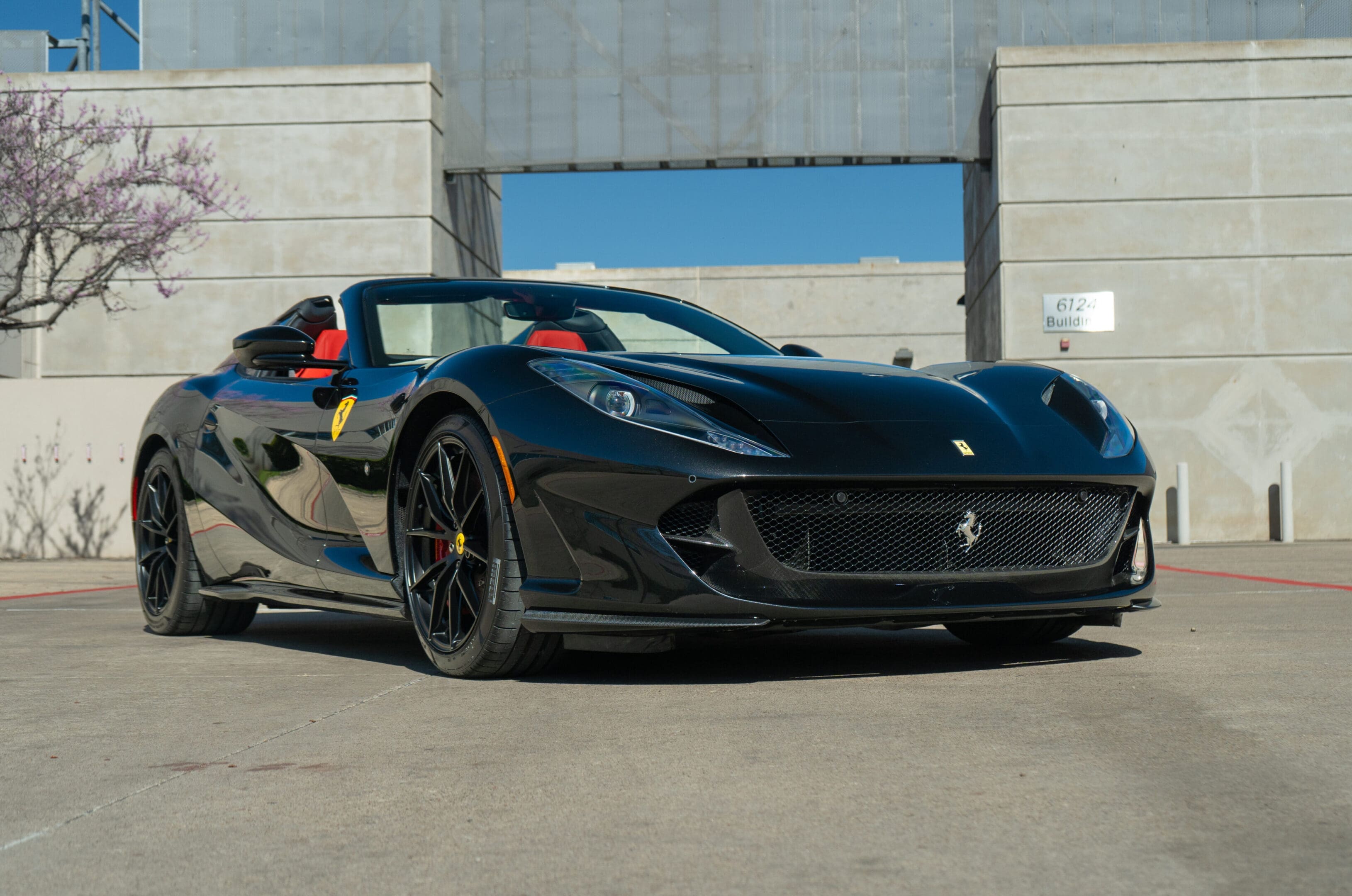 Black Ferrari convertible parked in urban lot